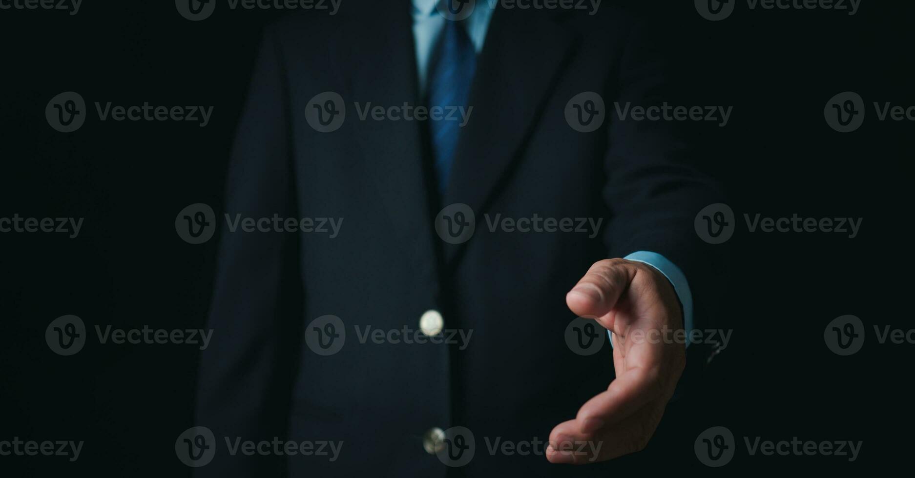 uomo d'affari in piedi e fare stretta di mano gesto su buio sfondo. attività commerciale concetto. copia spazio. foto