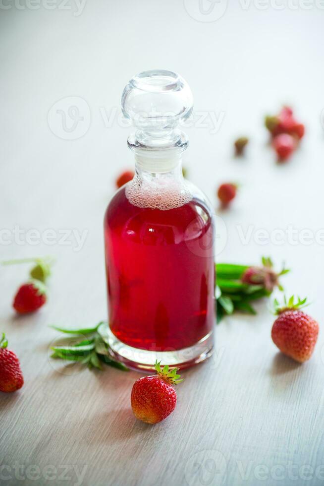 dolce cucinato fragola sciroppo nel un' bicchiere caraffa foto