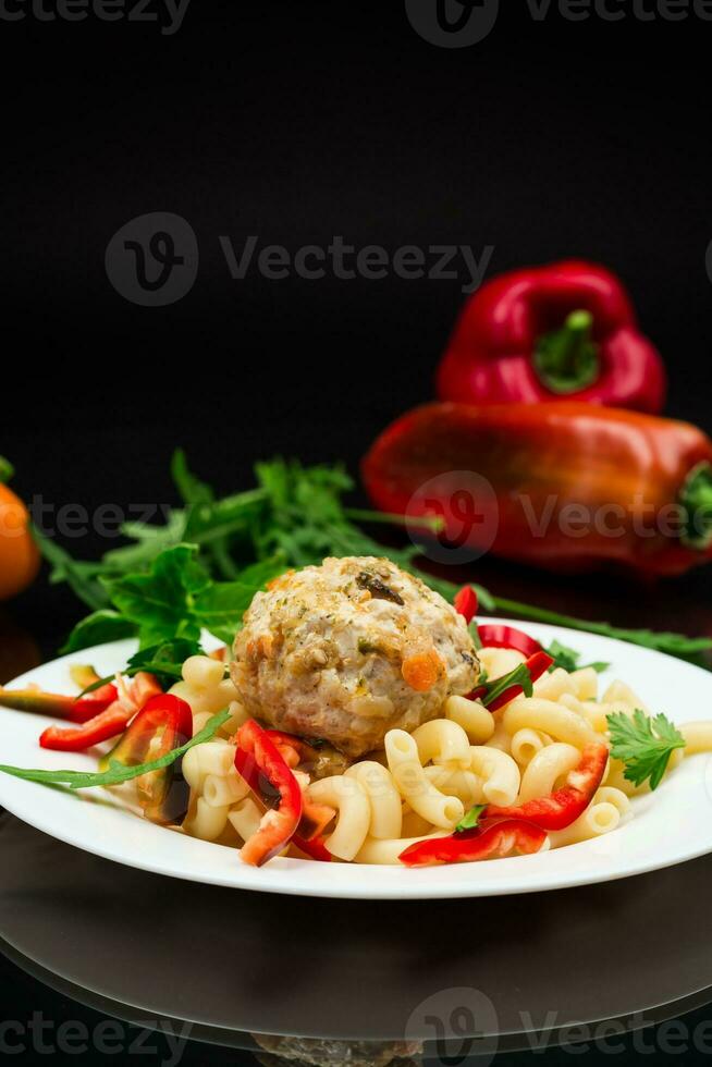 cucinato pasta con Polpette, peperoni e erbe aromatiche con spezie nel un' piatto foto