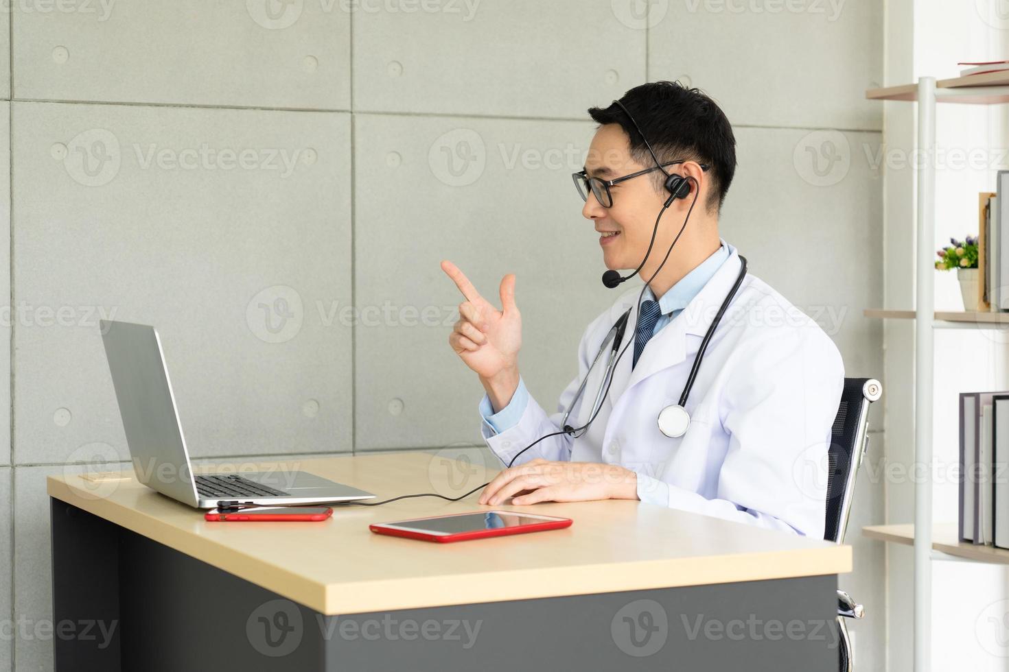 il medico asiatico dà consulto al paziente tramite videochiamata foto