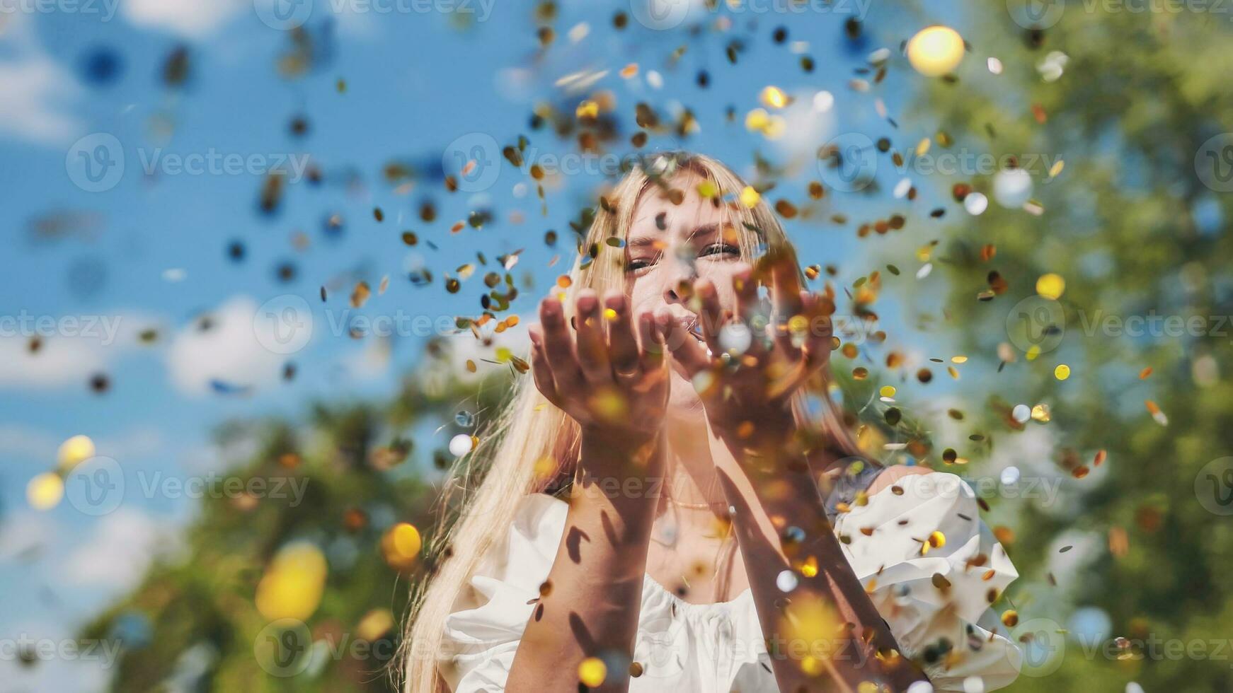 il ragazza colpi un' d'oro coriandoli su di sua mani. foto