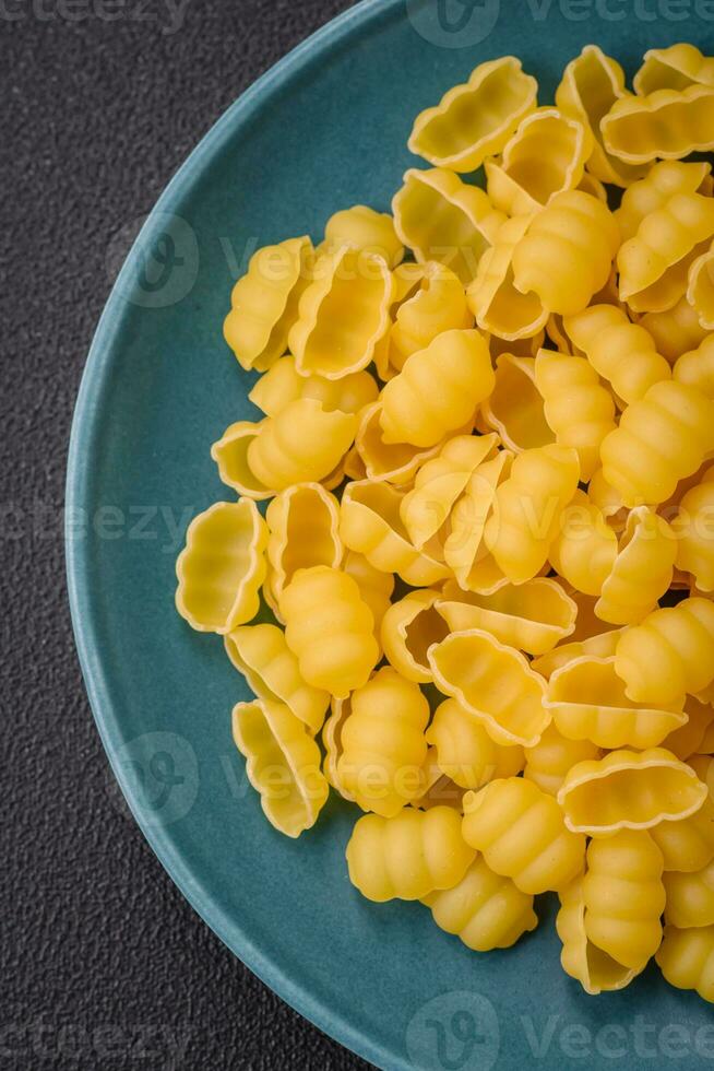 crudo duro Grano Gnocchi pasta con sale e spezie nel un' ceramica piatto foto