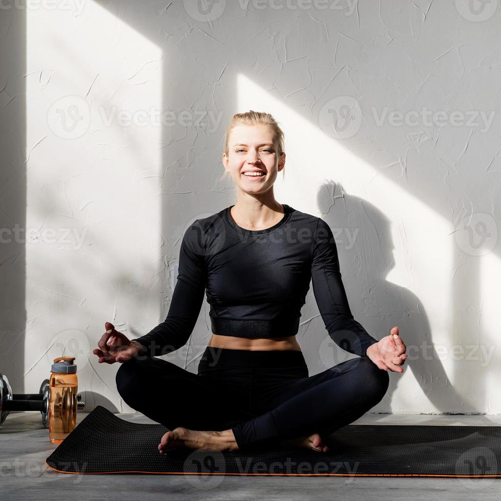giovane donna bionda che fa yoga o medita a casa foto