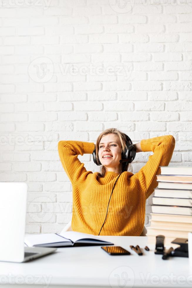 donna seduta alla scrivania che si rilassa dopo un lungo studio foto