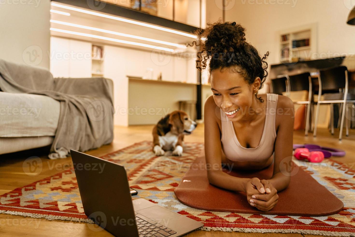 giovane donna nera che utilizza il computer portatile mentre fa esercizio durante l'allenamento foto