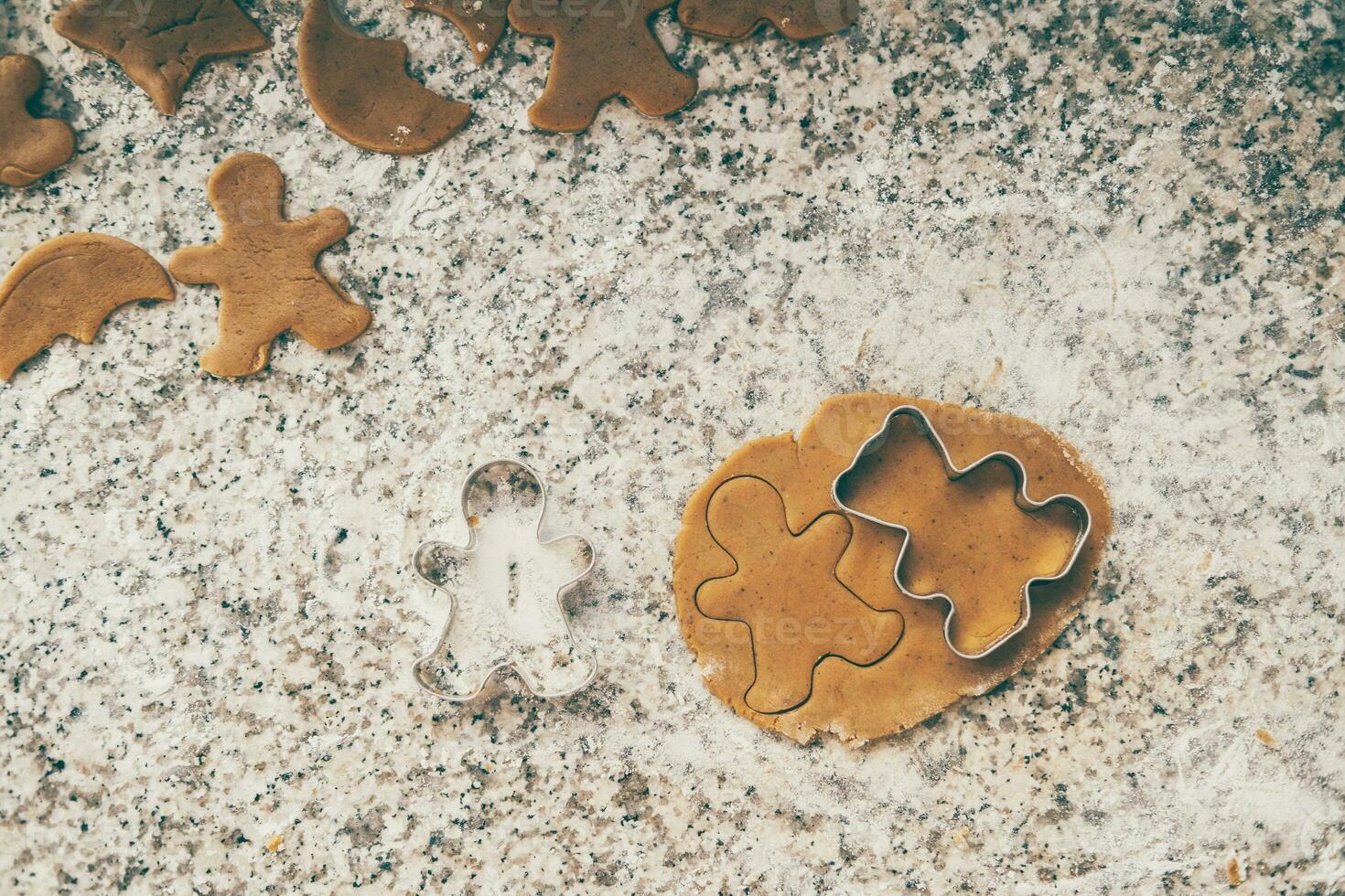 fabbricazione Natale biscotti. immaginato Pan di zenzero biscotti su il cucina tavolo con vacanza luci foto