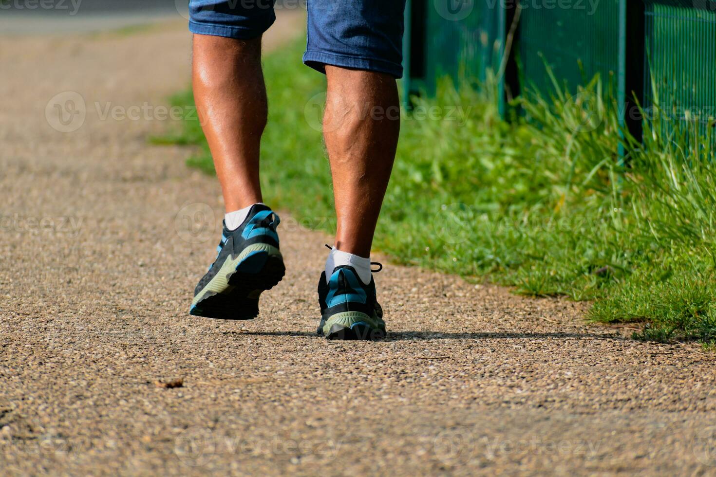 uomo a piedi con scarpe da ginnastica su un' sentiero, avvicinamento di il suo gambe, gli sport attività, salutare lifetsyle foto