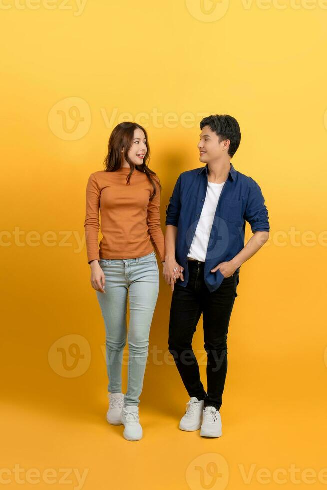 pieno Visualizza di giovane asiatico coppia a piedi Tenere mani su blu sfondo. foto
