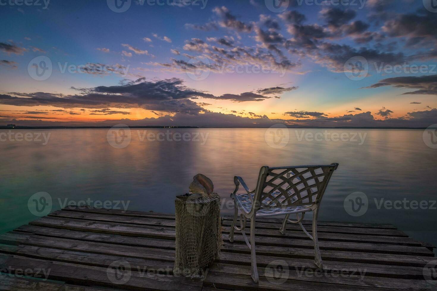 vuoto sedia su un' di legno molo in attesa per Alba su il mare spiaggia. foto
