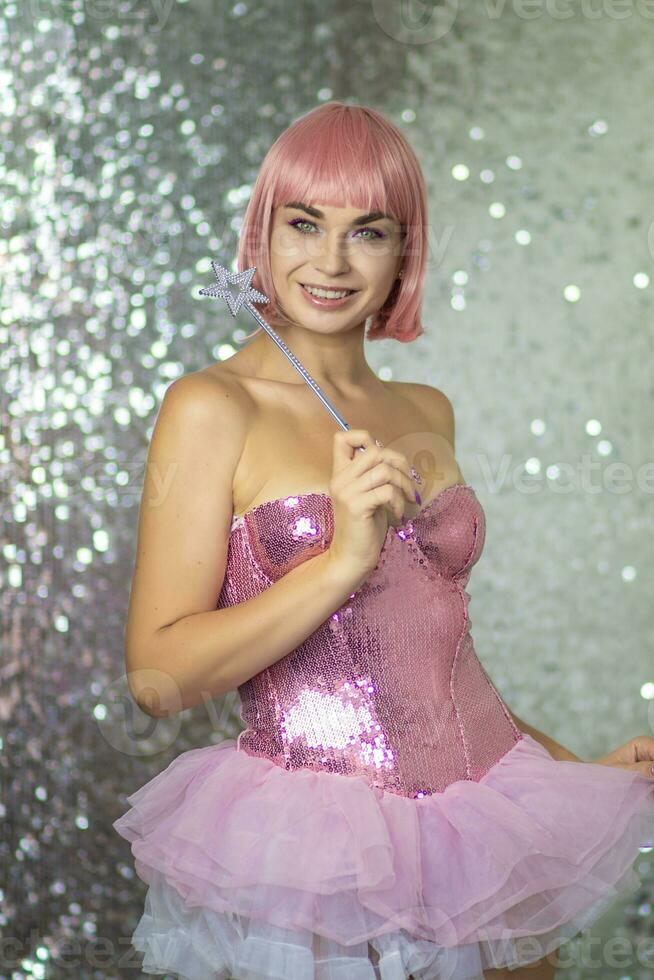donna nel un' corto rosa parrucca con un' Magia bacchetta magica foto