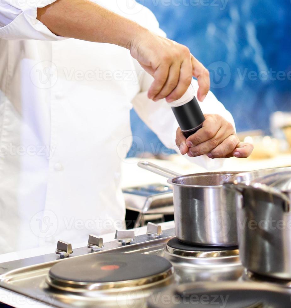 chef che cucina cibo in cucina, chef che prepara cibo foto