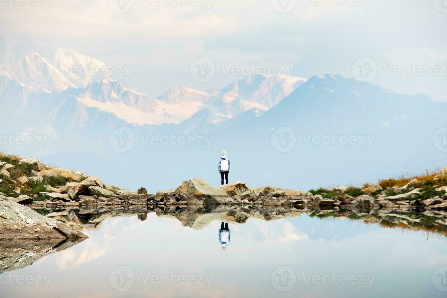 statico Visualizza turista donna In piedi di udziro lago punto di vista orologio neve picchi Caucaso gamma sfondo nel racca, georgiano regione. udziro lago escursioni a piedi pista foto