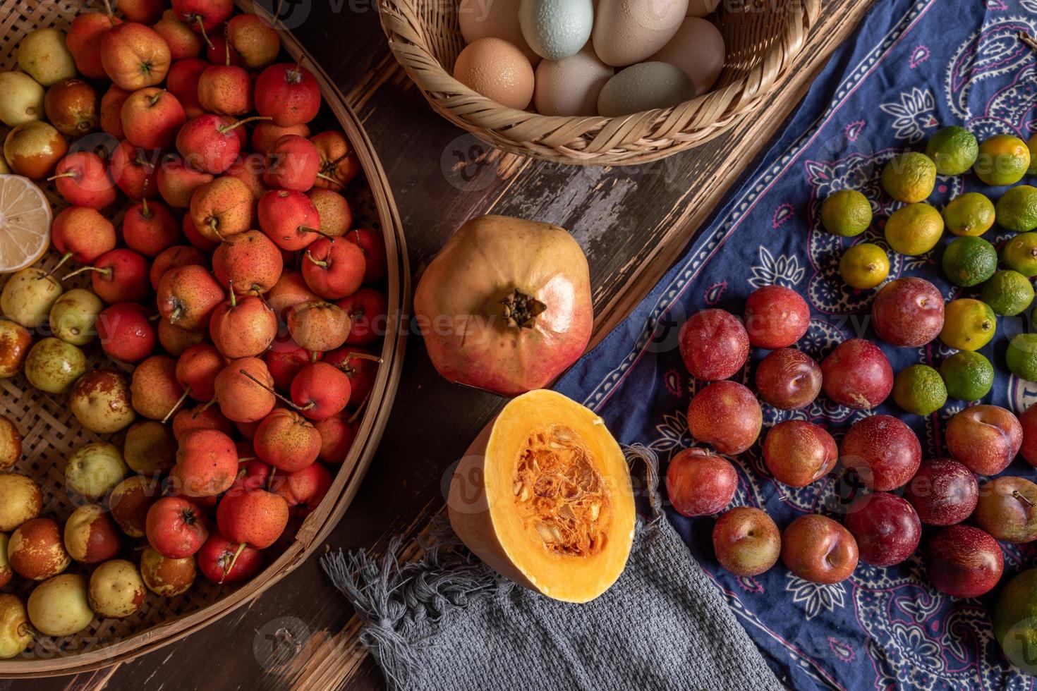 zucche e molti altri colori e varietà di frutta e verdura sono sul tavolo delle venature del legno foto