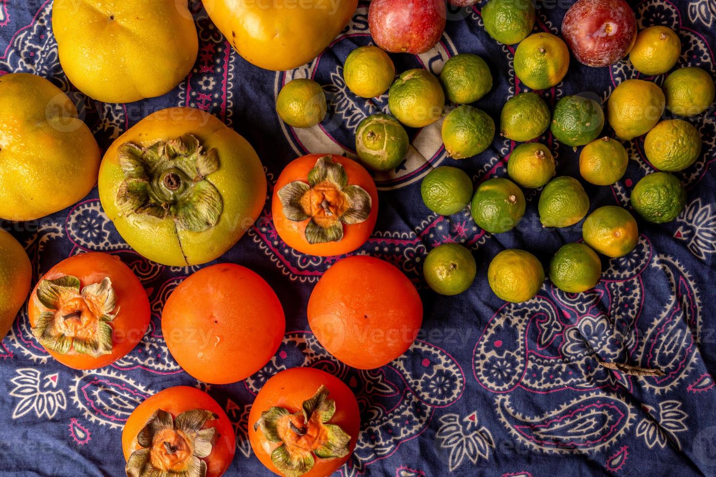 tanti colori e varietà di frutta sono nel piatto o sparsi sulla tavola di legno foto