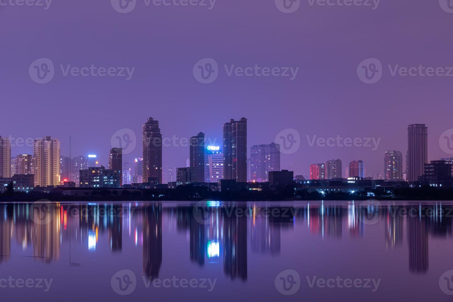 una città riflessa dal lago di notte foto