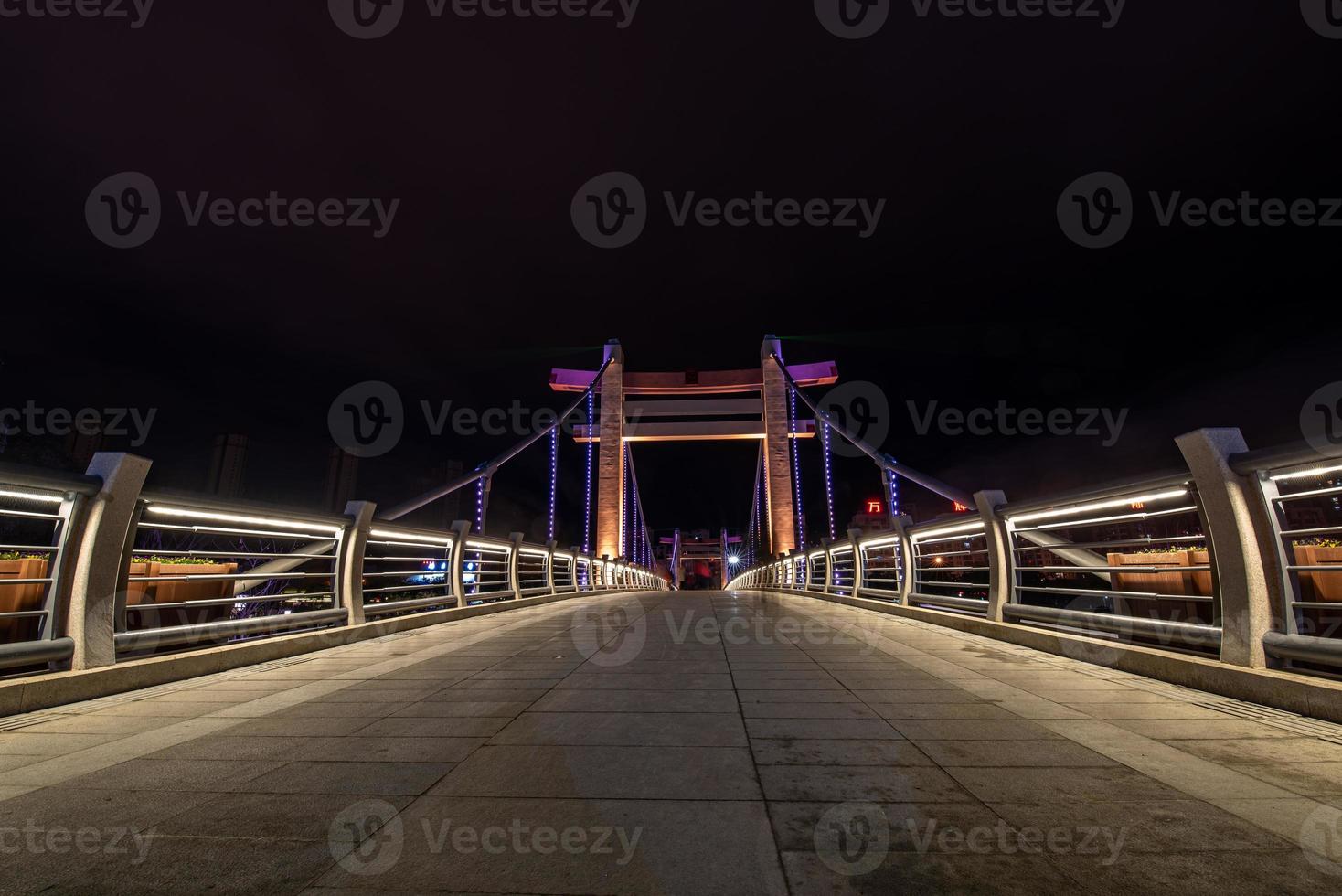 di notte, il ruscello riflette le luci colorate sul ponte foto