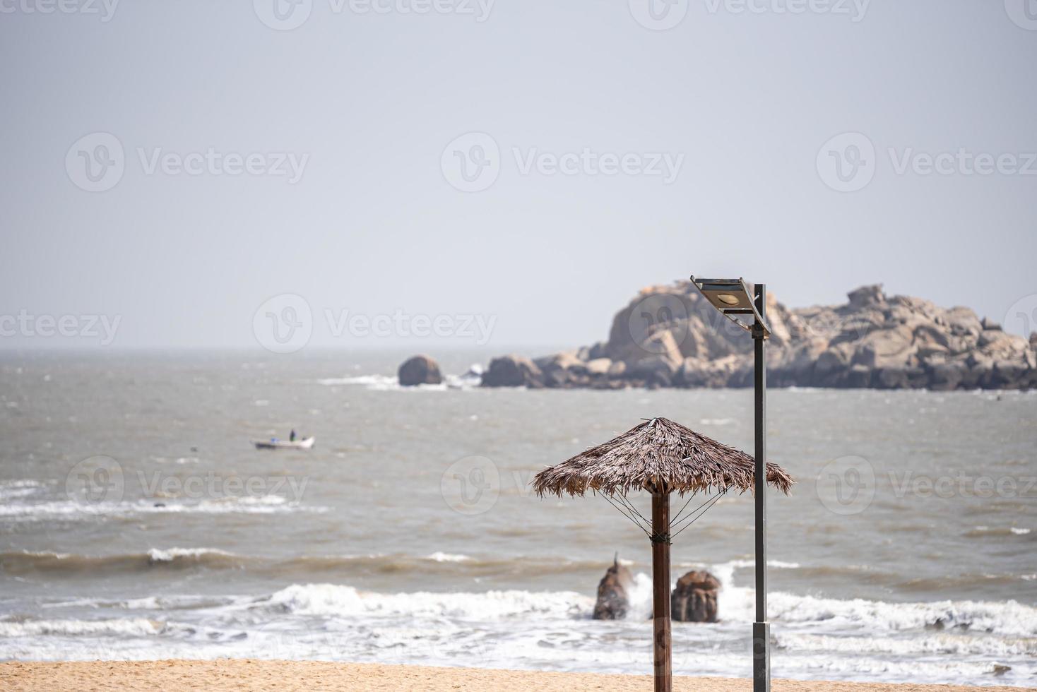 ci sono ombrelloni in erba sulla spiaggia in estate foto