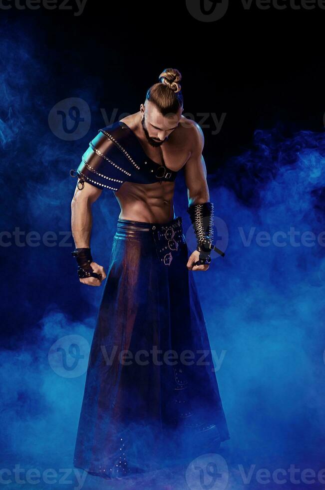 bello giovane sexy uomo con bellissimo muscolare il petto nel interessante costume su il scena foto