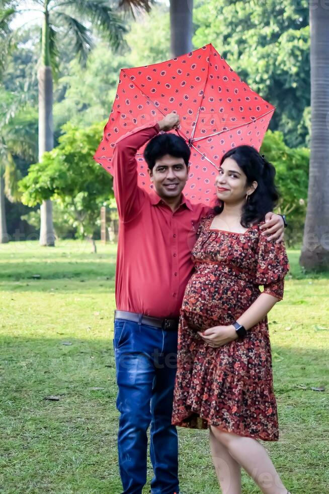 indiano coppia in posa per maternità sparare posa per accogliente nuovo Nato bambino nel lodhi strada nel delhi India, maternità foto sparare fatto di genitori per accogliente loro bambino, pre bambino foto sparare