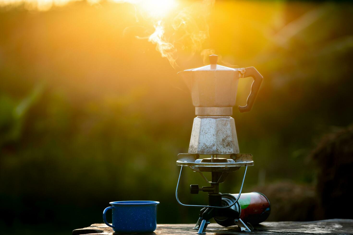 moka pentola e Fumo, vapore a partire dal il caffè pentola su fuoco, nel il foresta a Alba nel il mattina. morbido messa a fuoco. superficiale messa a fuoco effetto. foto