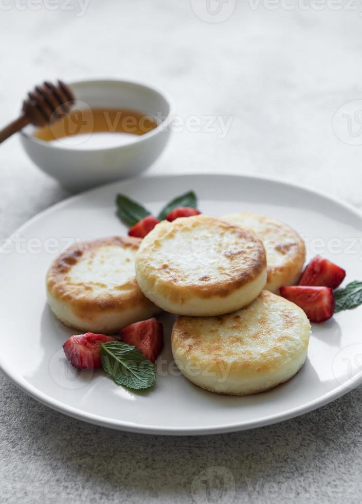 frittelle di ricotta, frittelle di ricotta su piatto di ceramica con fragole fresche foto