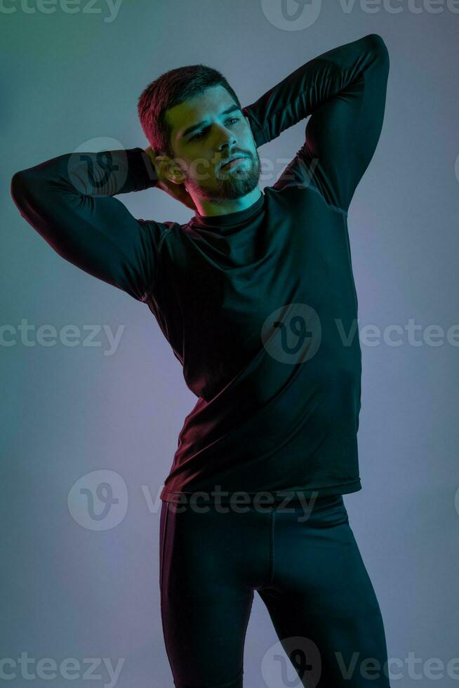 giovane muscolare uomo in posa su grigio sfondo foto