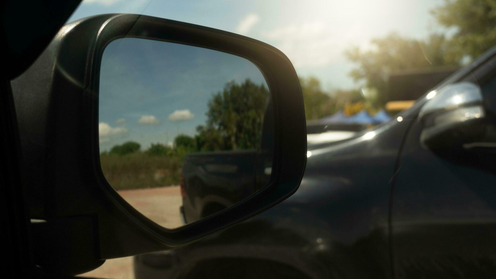 specchio ala di auto con altro auto parcheggio accanto. nel là specchio ala con suolo strada nel il bicchiere. foto
