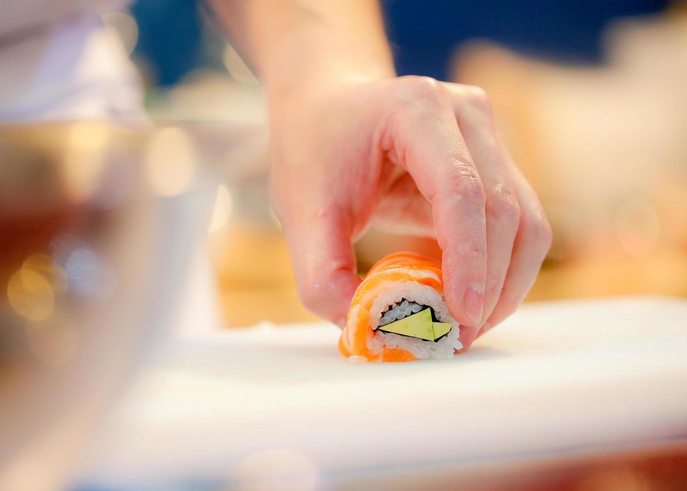 mani dello chef che preparano cibo giapponese, chef che prepara sushi foto