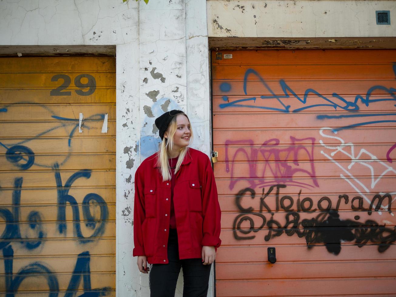 giovane ragazza in berretto lavorato a maglia e giacca rossa sorridente foto