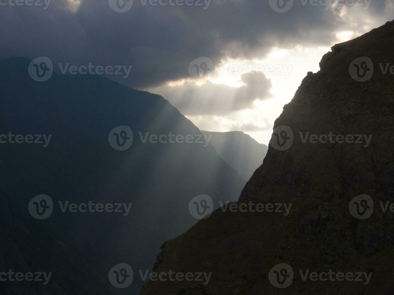 un' montagna con un' raggio di sole In arrivo attraverso il nuvole foto