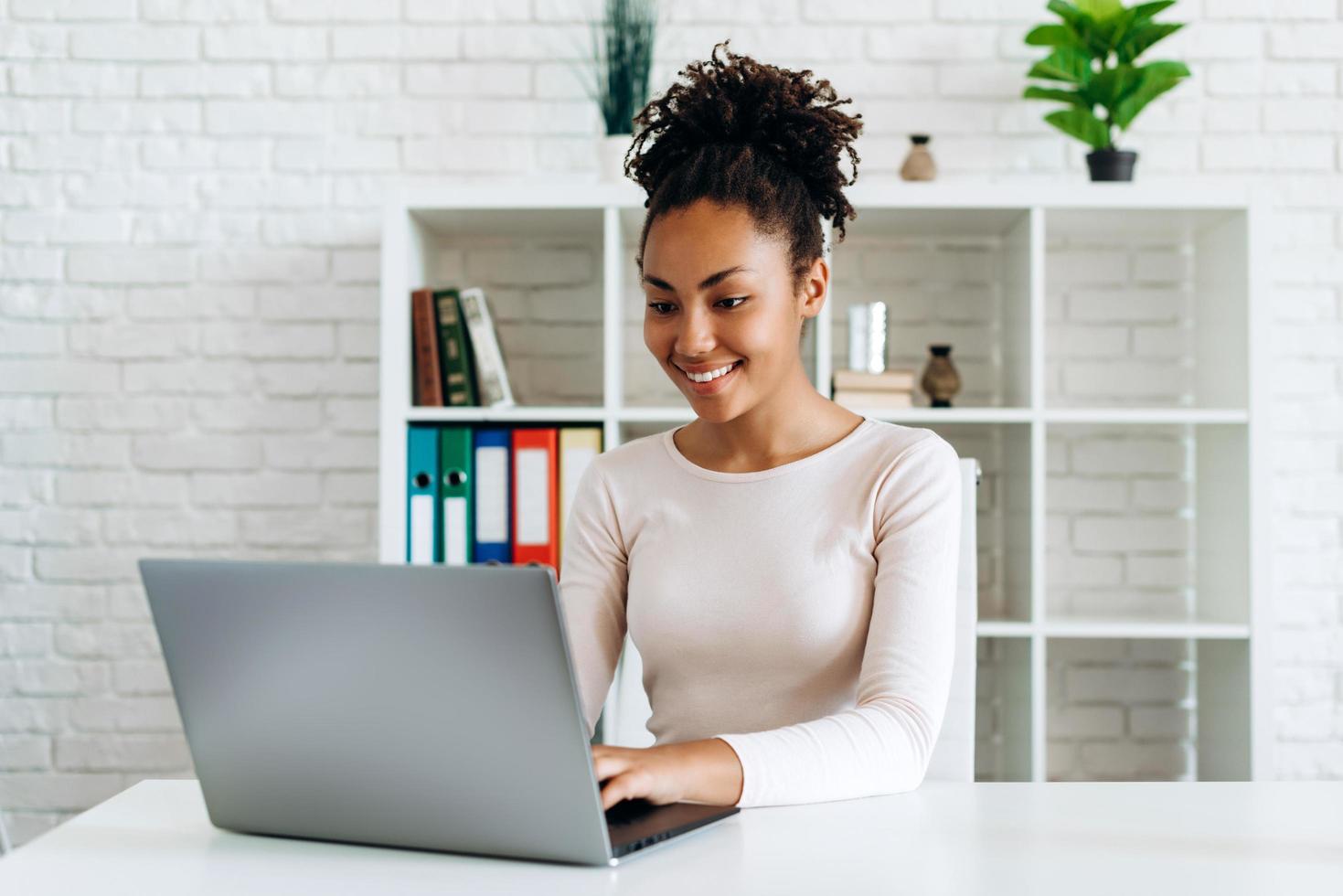 bella ragazza che lavora al computer a casa foto