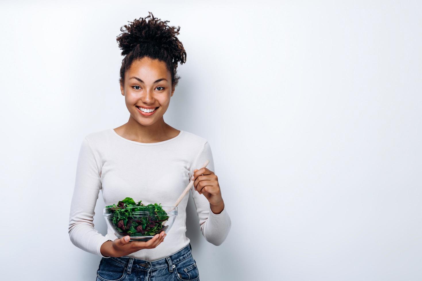 il concetto di mangiare sano, ragazza con una ciotola di insalata, su uno sfondo bianco, mangiare sano foto