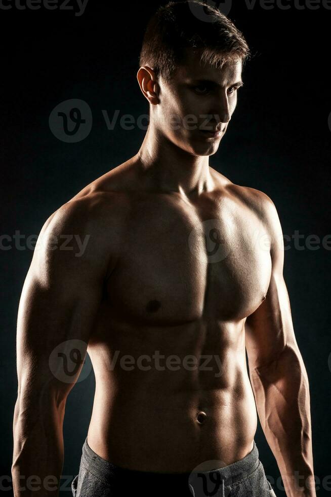 potente fitness uomo mostrando il suo grande corpo con manubri foto