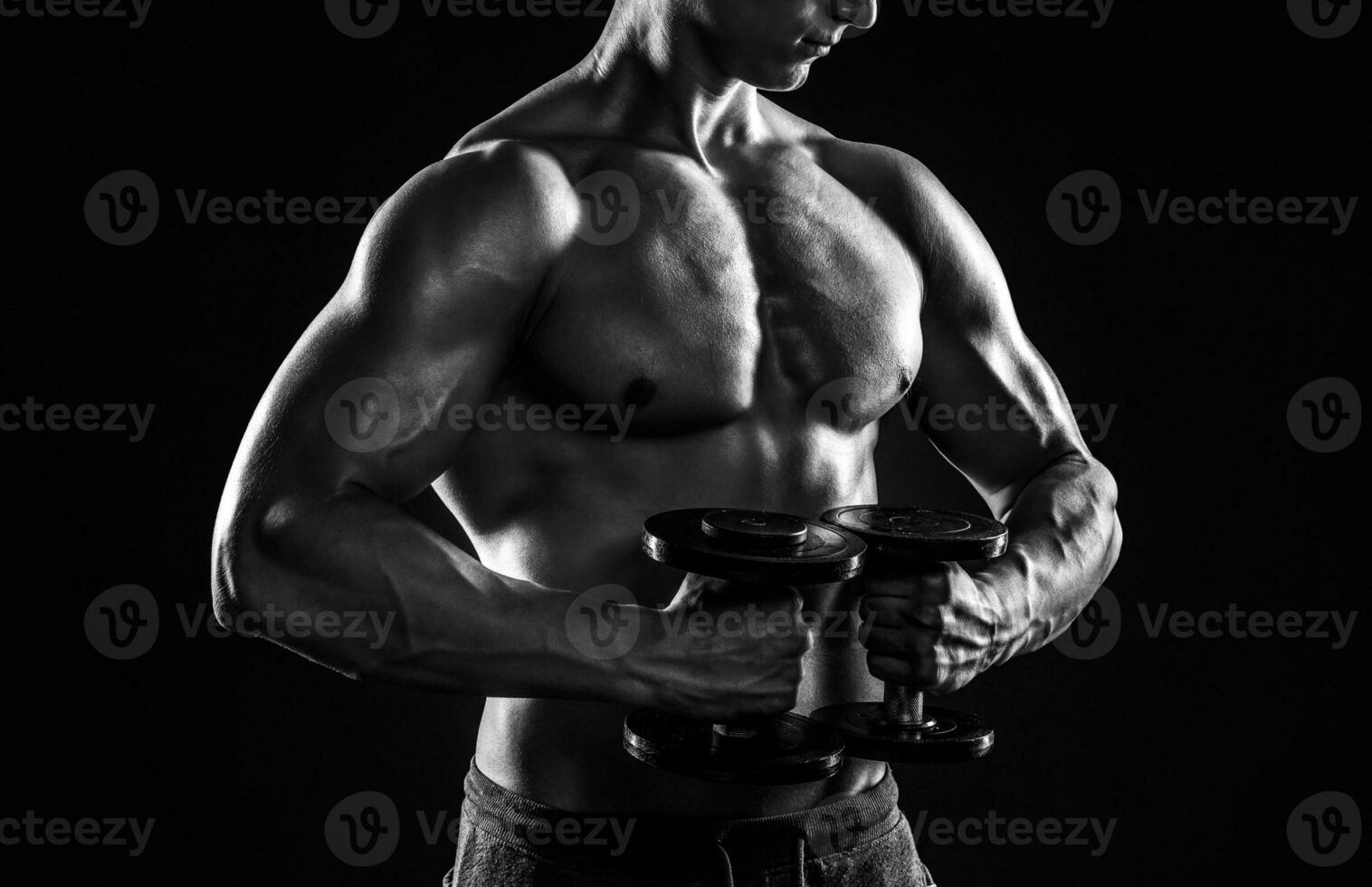 potente fitness uomo mostrando il suo grande corpo con manubri foto