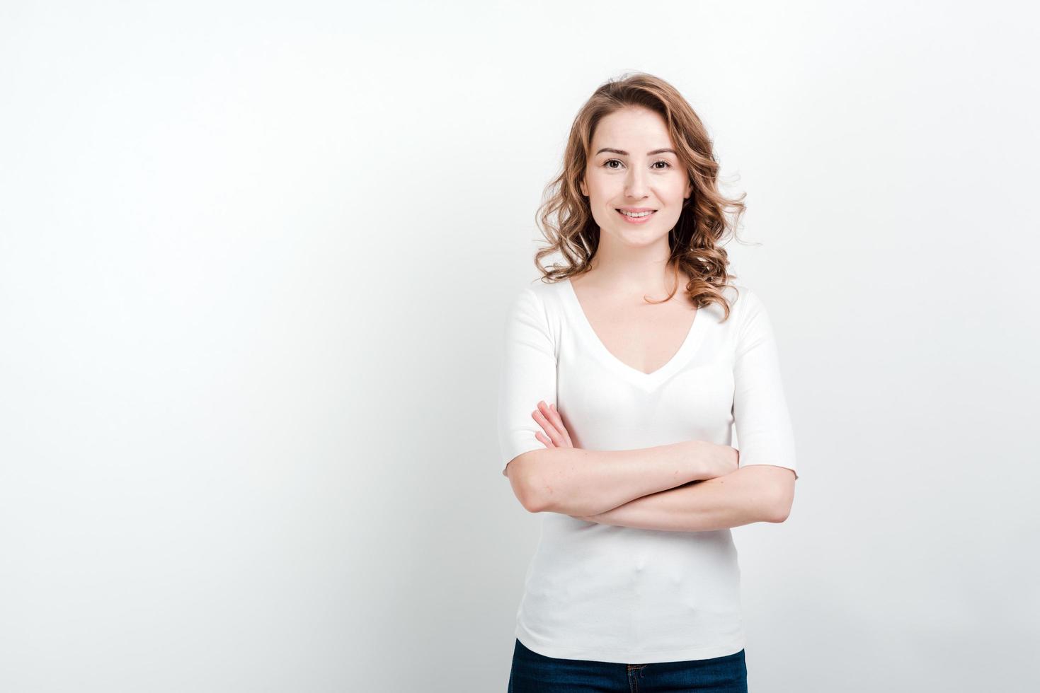 ritratto di donna in piedi su uno sfondo di studio incrociò le mani foto