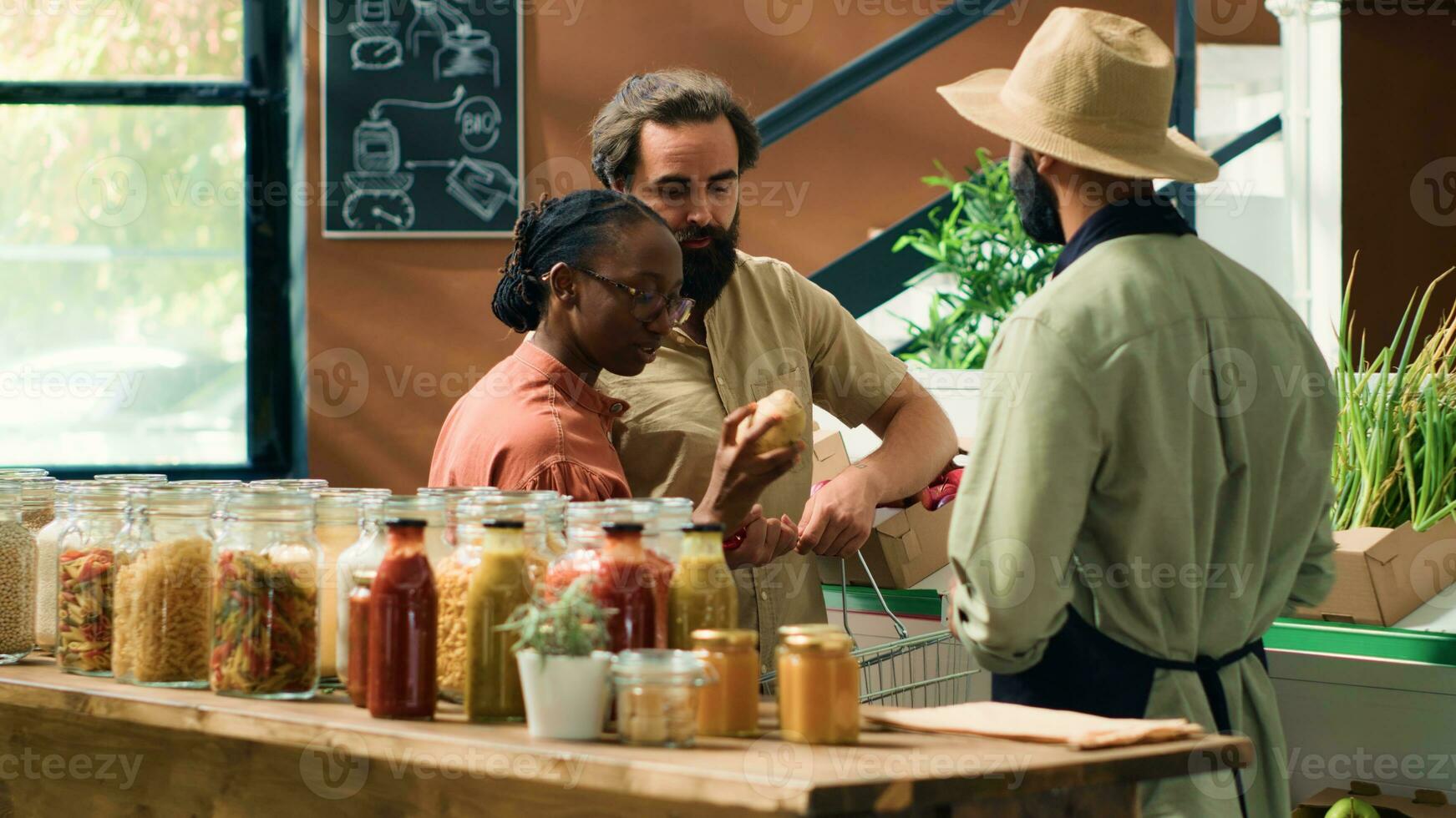 mercante assiste i clienti nel drogheria negozio, mostrando appena raccolto frutta e verdure. giovane coppia ricerca per biologico produrre a Locale zero rifiuto supermercato, sostenibile stile di vita. foto