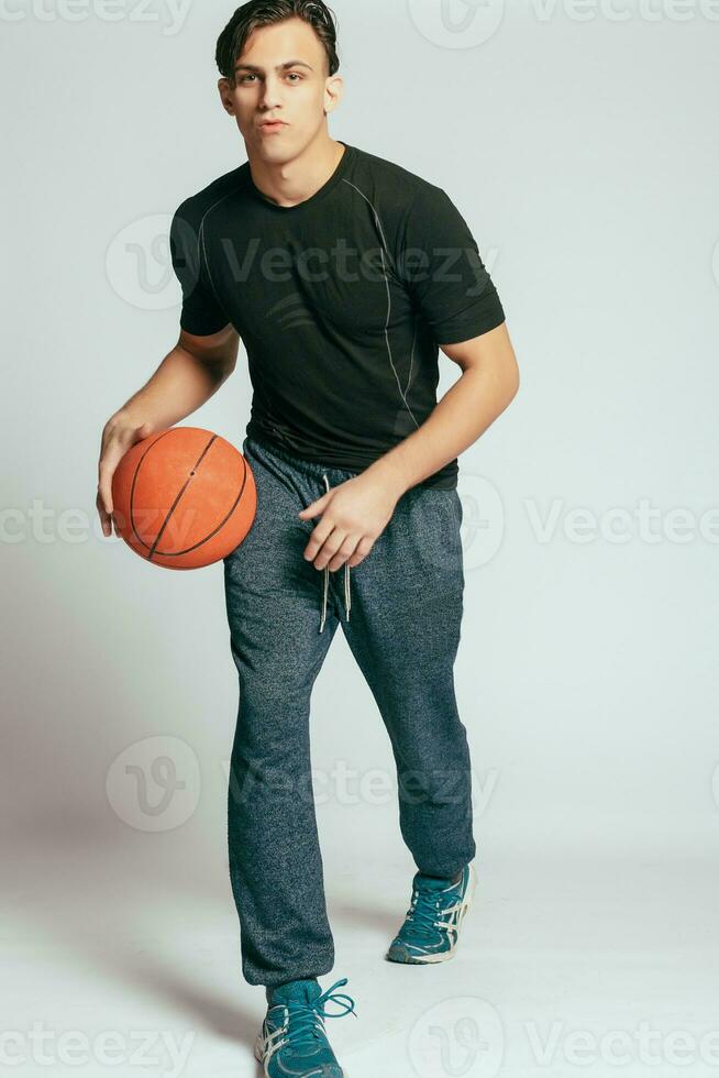 bello giovane sorridente uomo trasporto un' pallacanestro palla foto