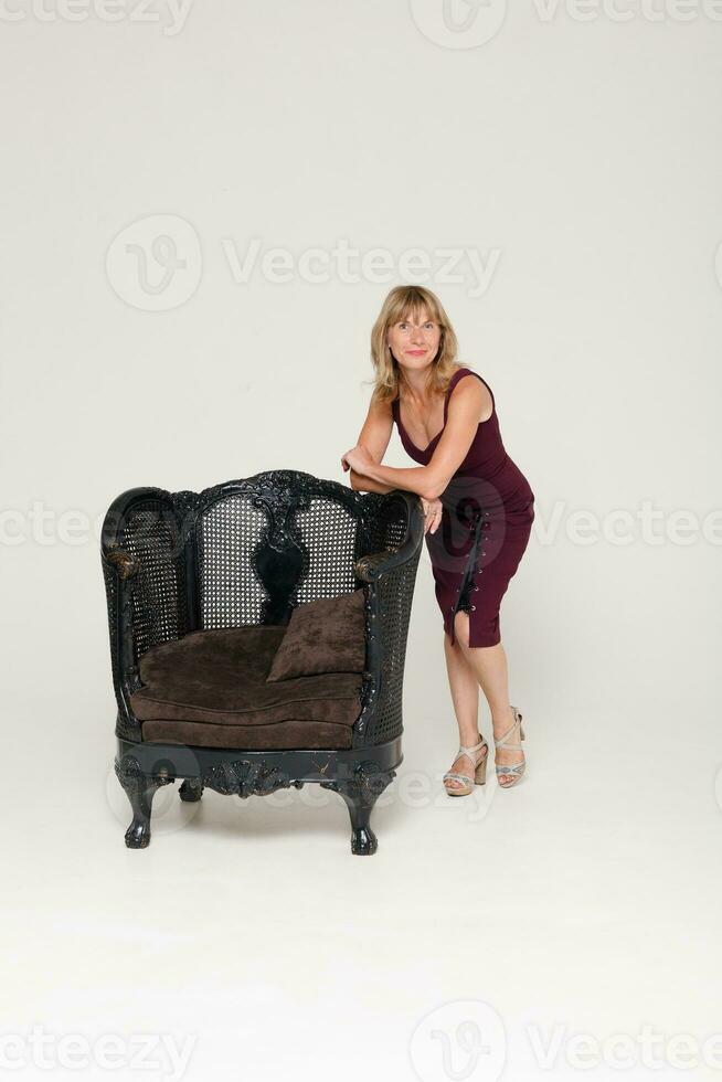 ritratto di un' sbalorditivo alla moda modello seduta nel un' sedia foto