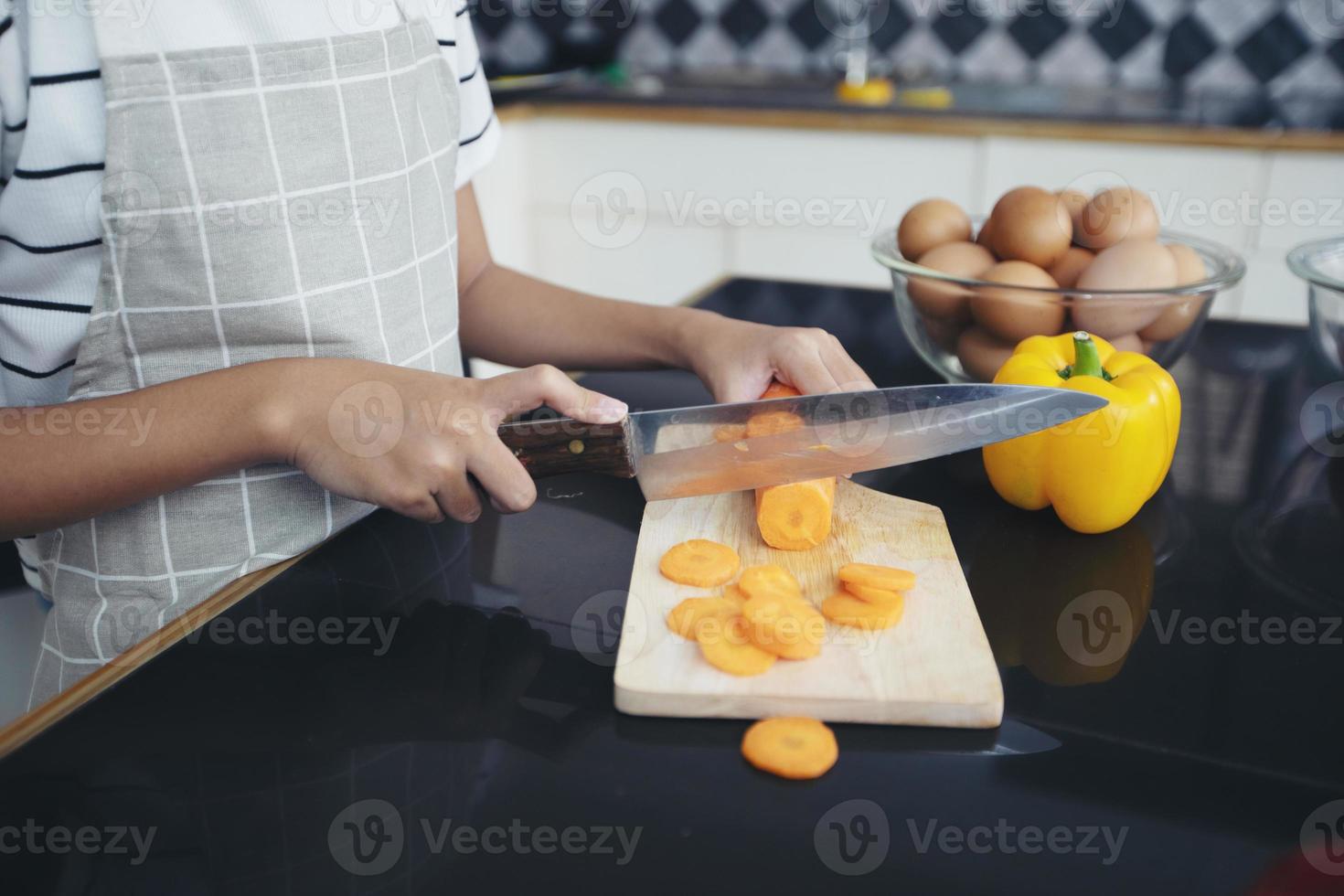 la famiglia felice ha papà, mamma e la loro piccola figlia che cucinano insieme in cucina foto