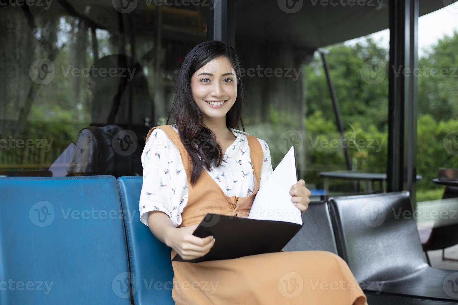 donne asiatiche che leggono e sorridono e si rilassano felici in una caffetteria dopo aver lavorato in un ufficio di successo. foto