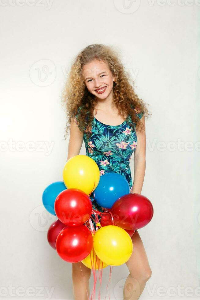 adolescenziale ragazza con elio palloncini al di sopra di grigio sfondo foto