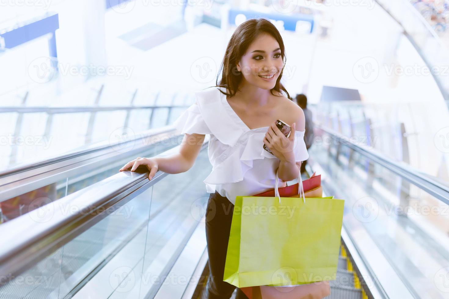 le donne asiatiche e la bella ragazza tengono in mano le borse della spesa sorridendo mentre fanno la spesa al supermercato foto