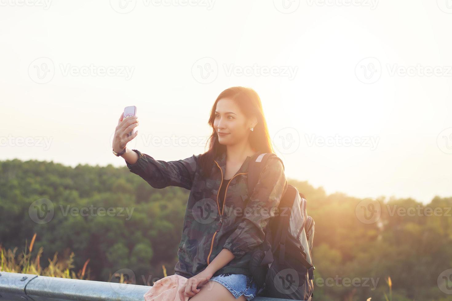 le donne asiatiche sorridenti stanno scattando foto e selfie