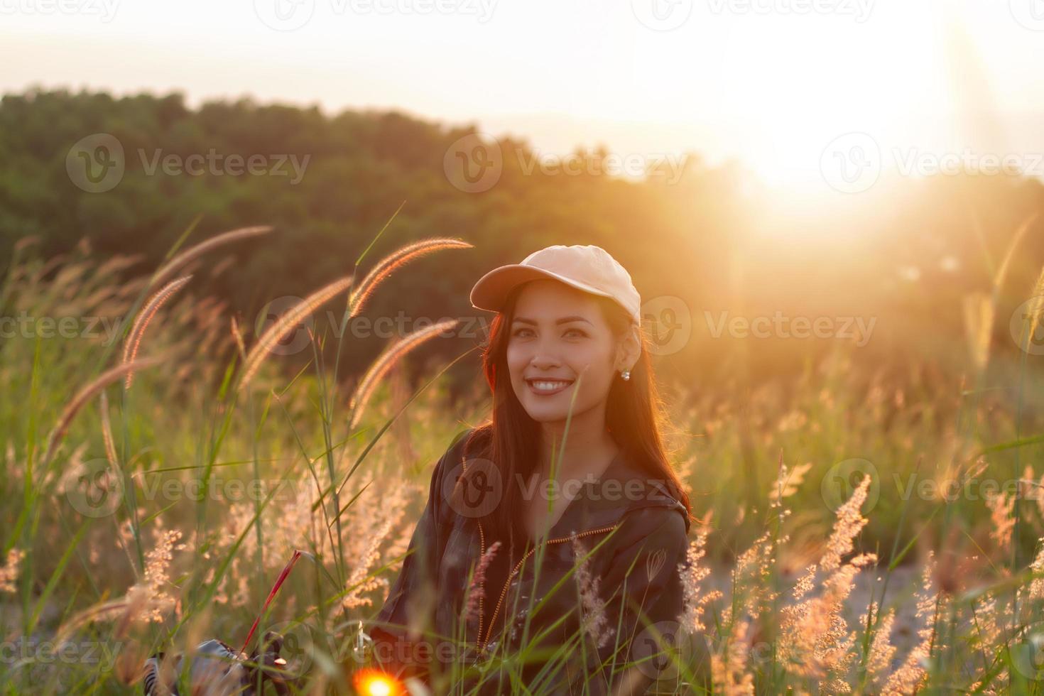 ritratto donna asiatica backpacking. era sorridente e felice di viaggiare all'alba sul picco di montagna sul mare foto