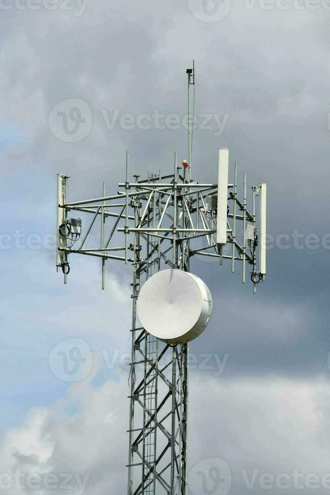 un' cellula Telefono Torre con un' satellitare piatto su superiore foto