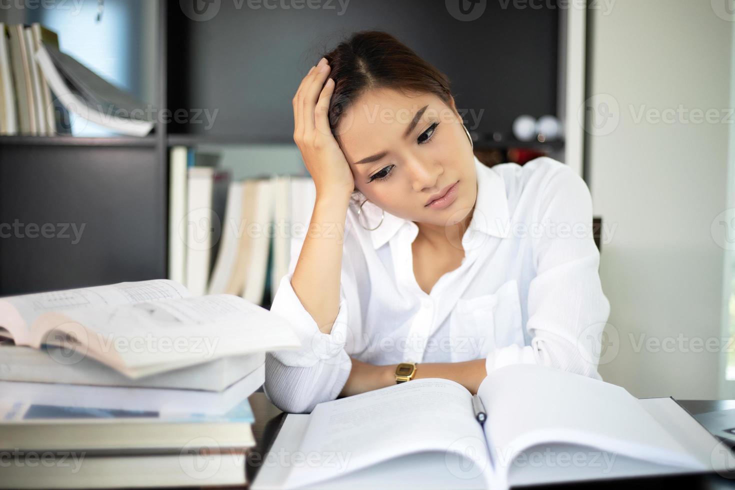 donna d'affari asiatica e studentessa seria riguardo al libro di lettura e al duro lavoro fino al mal di testa foto