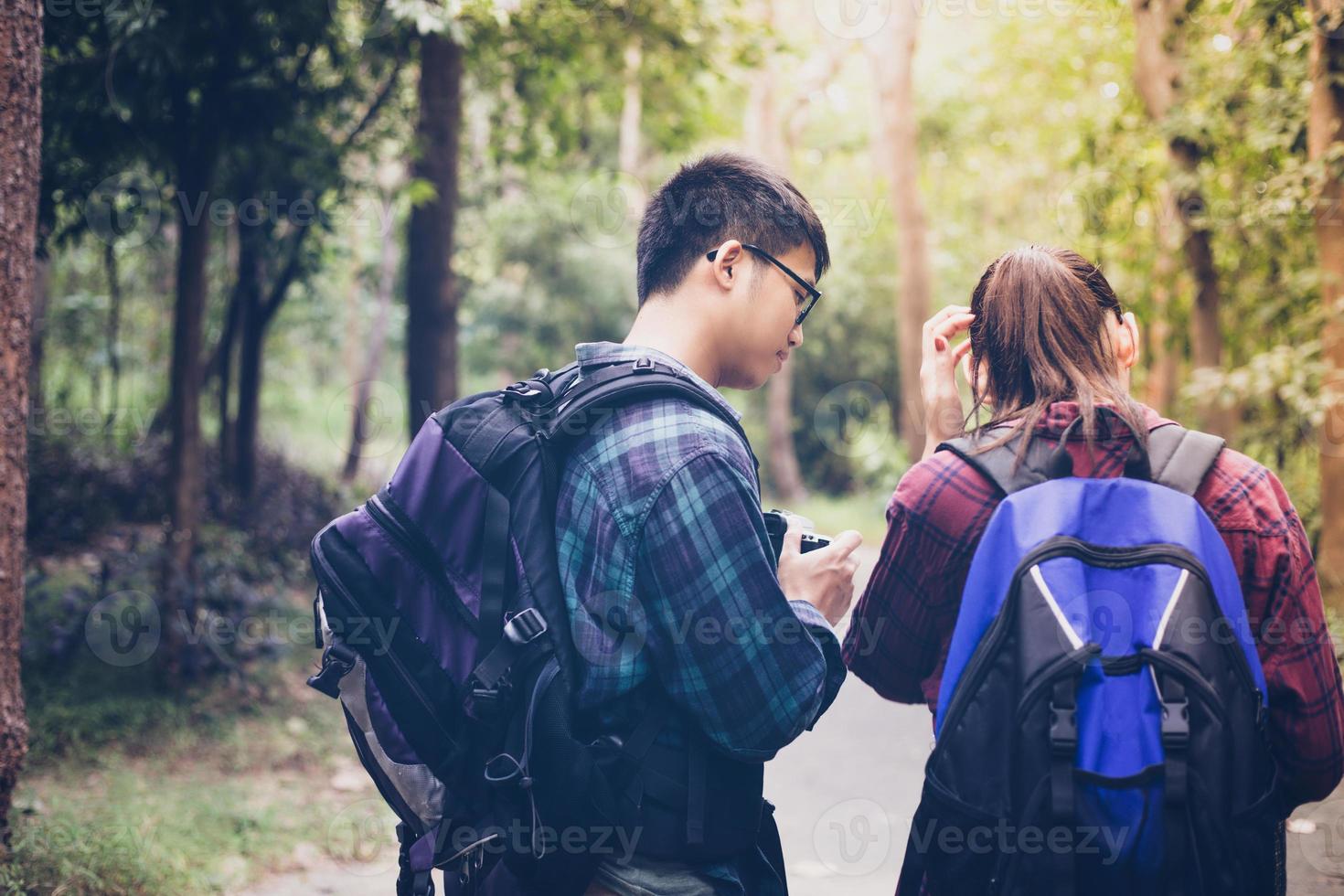 gruppo asiatico di giovani che fanno escursioni con gli amici zaini camminano insieme e guardano la mappa e prendono la macchina fotografica lungo la strada e sembrano felici, tempo di relax durante il concetto di vacanza viaggio foto