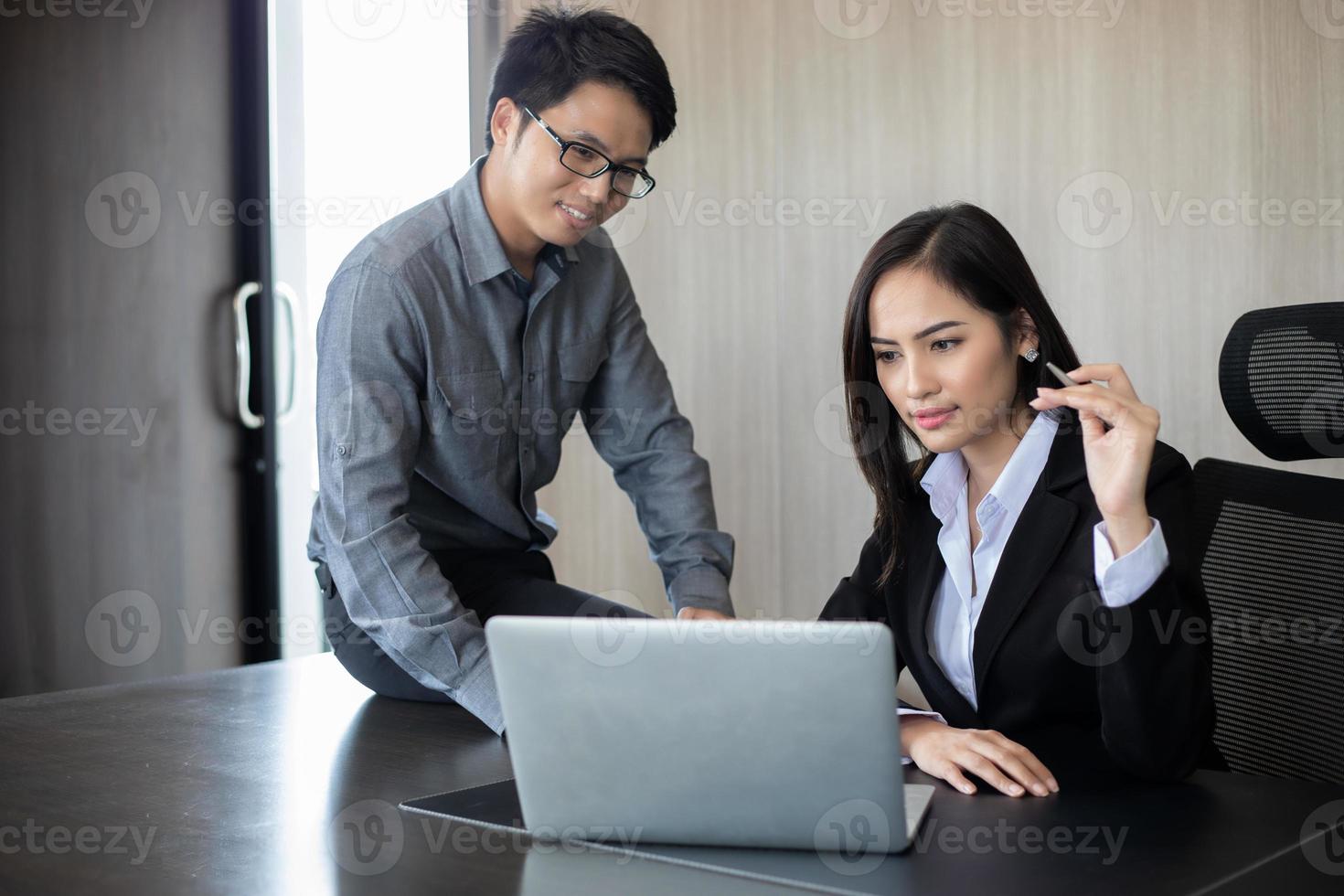 uomini d'affari asiatici e gruppi che utilizzano notebook per partner commerciali che discutono documenti e idee durante le riunioni e donne d'affari che sorridono felici per il lavoro foto