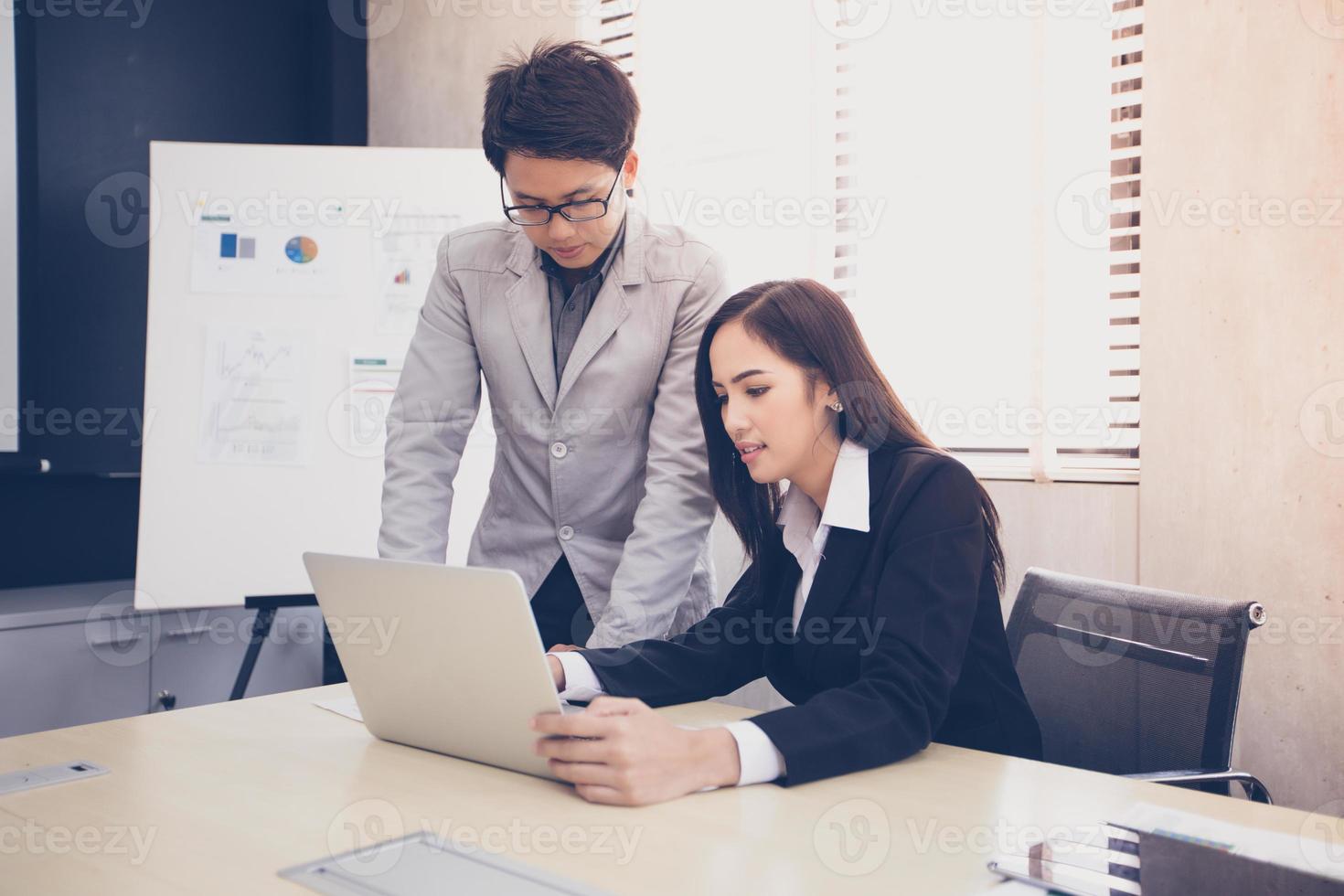 uomini d'affari asiatici e gruppi che utilizzano notebook per partner commerciali che discutono documenti e idee durante le riunioni e donne d'affari che sorridono felici per il lavoro foto