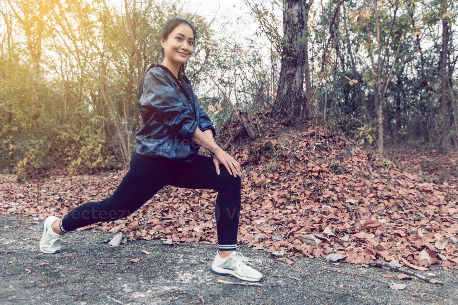 donna atletica asia in fase di riscaldamento e giovane atleta femminile che si esercita e si allunga in un parco prima del corridore all'aperto, concetto di stile di vita sano. foto